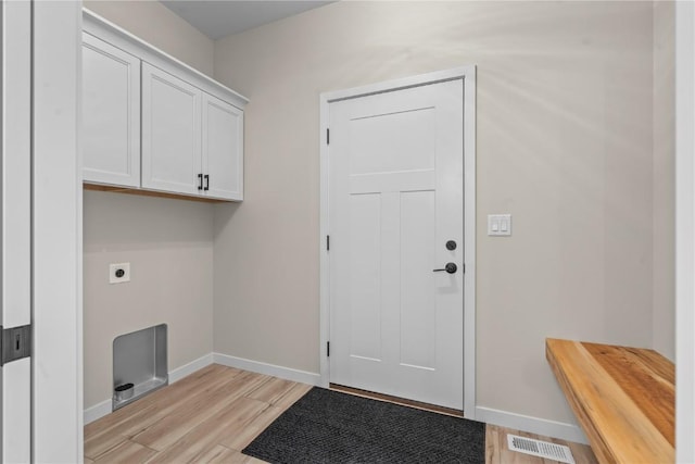 laundry area featuring light hardwood / wood-style floors, cabinets, and hookup for an electric dryer