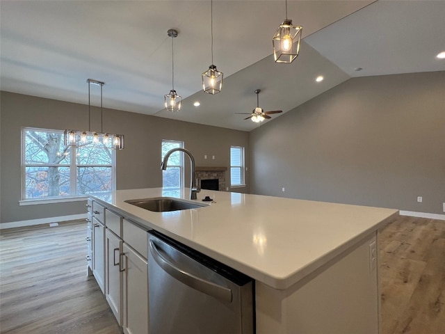 kitchen with dishwasher, a center island with sink, sink, light hardwood / wood-style flooring, and white cabinetry