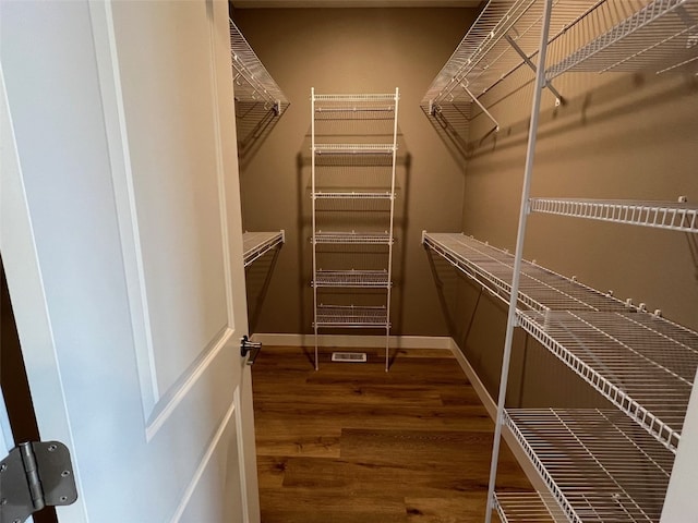 spacious closet featuring dark hardwood / wood-style flooring