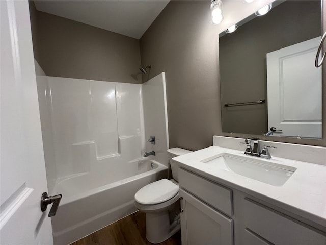 full bathroom with hardwood / wood-style floors, vanity, toilet, and shower / washtub combination