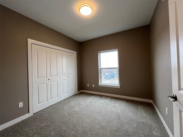 unfurnished bedroom with carpet flooring and a closet