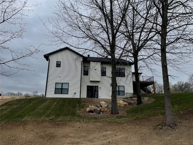 rear view of house featuring a yard and a deck