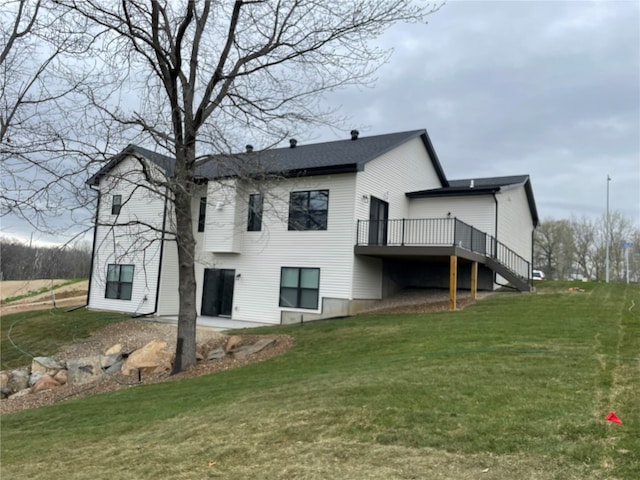 back of house featuring a lawn and a deck