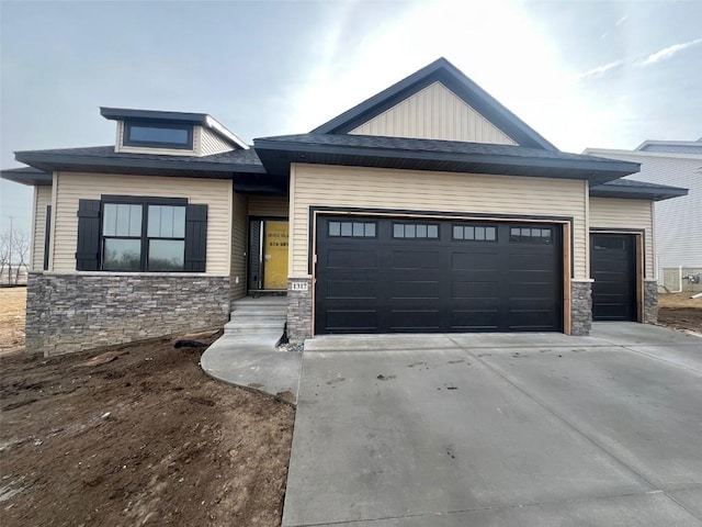 view of front of house featuring a garage, stone siding, and concrete driveway