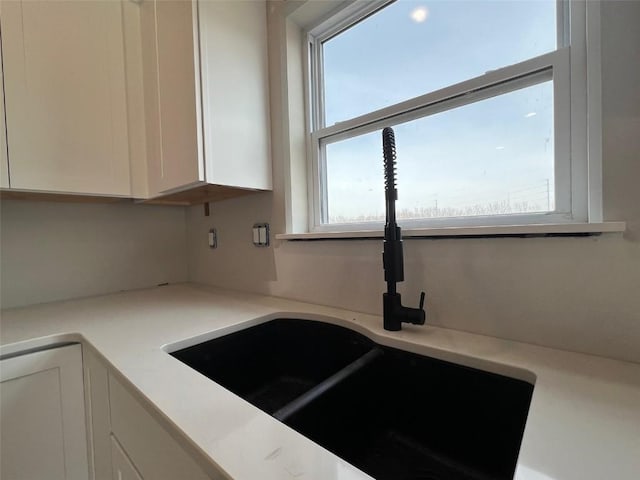 kitchen with white cabinetry and sink