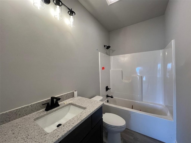 full bathroom with vanity, tub / shower combination, wood-type flooring, and toilet