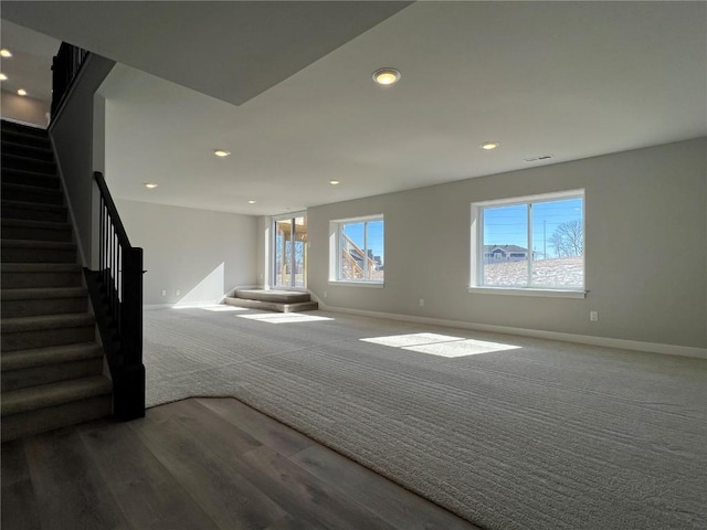 unfurnished living room with carpet floors, recessed lighting, baseboards, and stairs