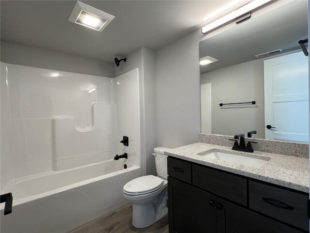 full bathroom featuring toilet, wood finished floors, vanity, visible vents, and tub / shower combination