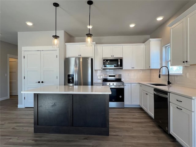 kitchen with stainless steel appliances, a center island, a sink, and backsplash