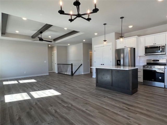 kitchen with decorative backsplash, dark wood-style floors, a center island, stainless steel appliances, and white cabinetry