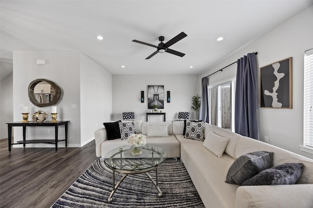 living room featuring ceiling fan and dark wood-type flooring