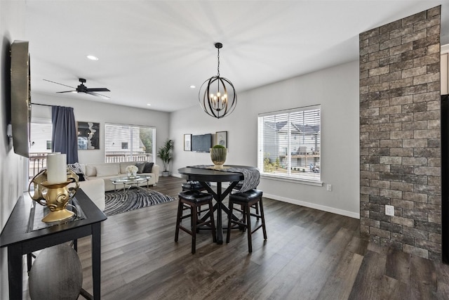 dining area with ceiling fan with notable chandelier, dark hardwood / wood-style flooring, and a wealth of natural light