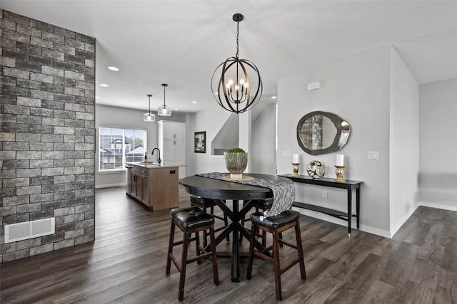 dining area with a notable chandelier, dark hardwood / wood-style floors, and sink