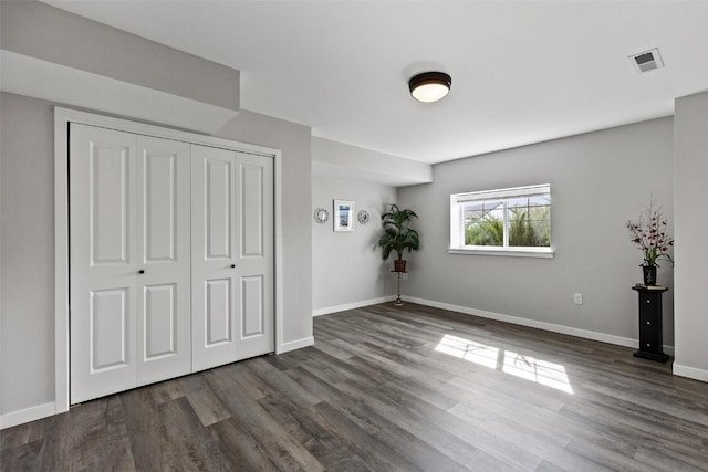 unfurnished bedroom with a closet and dark wood-type flooring