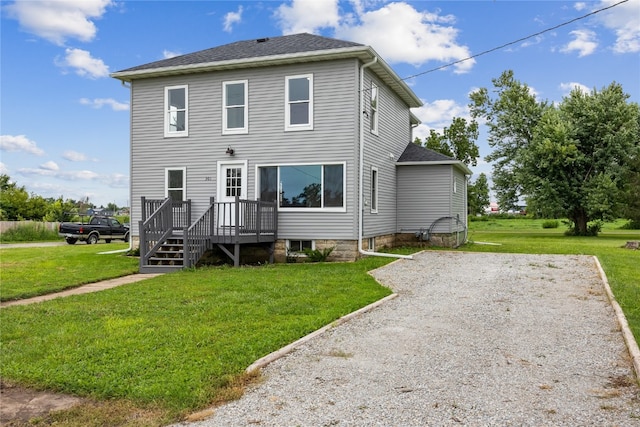 rear view of house featuring a yard