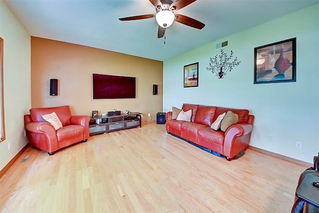 living area featuring visible vents, baseboards, ceiling fan, and wood finished floors