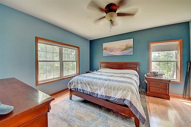 bedroom featuring a ceiling fan, baseboards, and light wood-type flooring