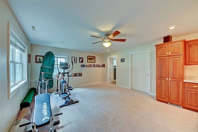 workout area with carpet, a ceiling fan, visible vents, and a wealth of natural light