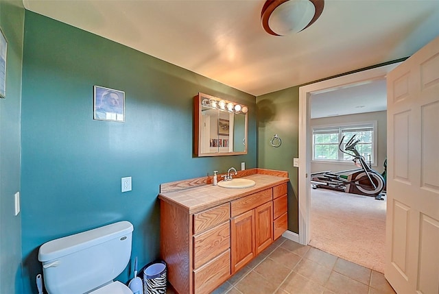 bathroom with tile patterned flooring, toilet, vanity, and baseboards