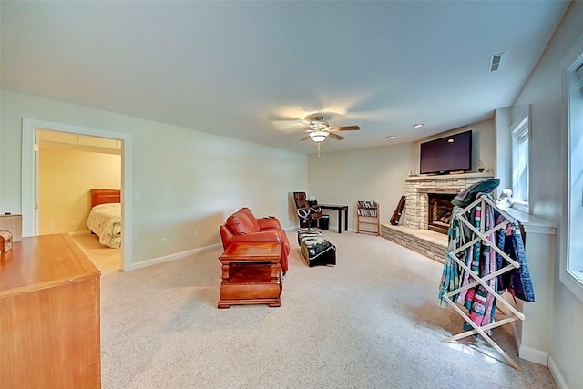 sitting room with visible vents, a fireplace, baseboards, and ceiling fan