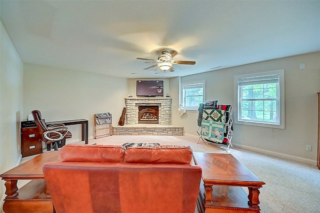 carpeted living room with a fireplace, baseboards, and ceiling fan