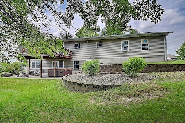 rear view of property featuring a hot tub, a yard, and a patio