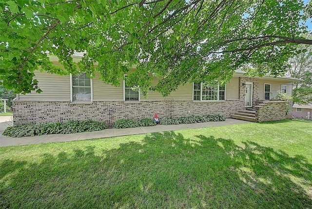 ranch-style house featuring a front yard and brick siding