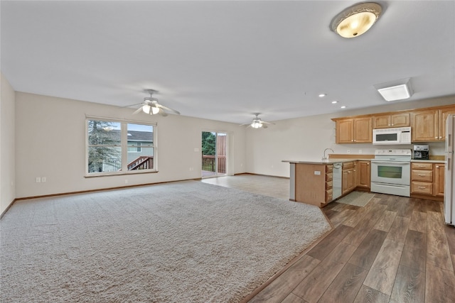 kitchen with white appliances, sink, kitchen peninsula, ceiling fan, and dark hardwood / wood-style floors