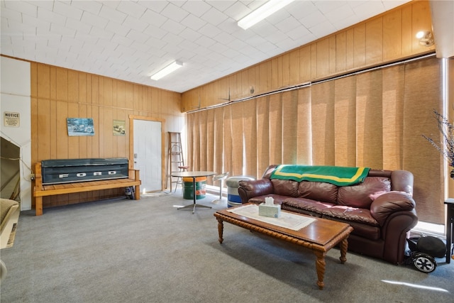 carpeted living room with wooden walls