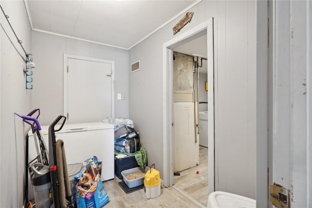 laundry room featuring light wood-type flooring and crown molding