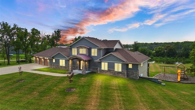 view of front facade with an attached garage, concrete driveway, a playground, and a front yard