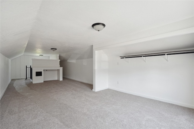 additional living space with lofted ceiling and light carpet