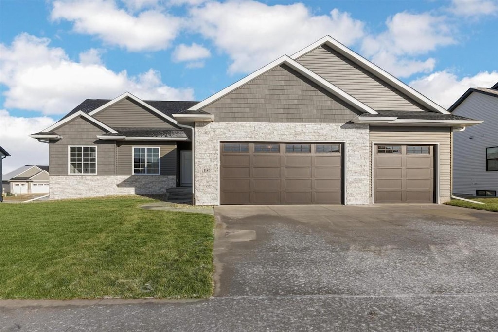 craftsman-style home featuring a garage and a front lawn