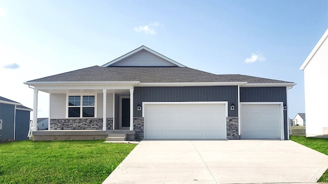 view of front of property featuring a garage, a front yard, and a porch