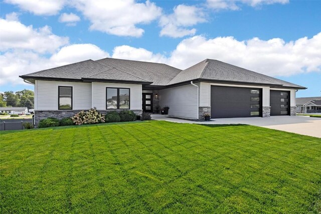 prairie-style home featuring a garage and a front lawn