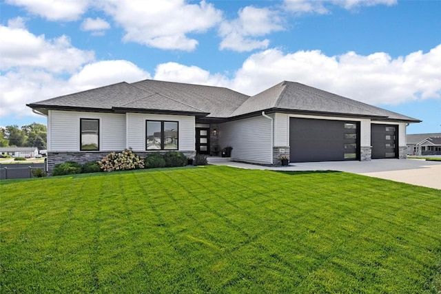 prairie-style house featuring stone siding, concrete driveway, a front lawn, and an attached garage