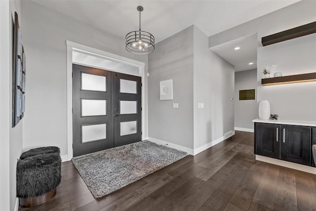 foyer entrance featuring dark wood-type flooring, french doors, and baseboards