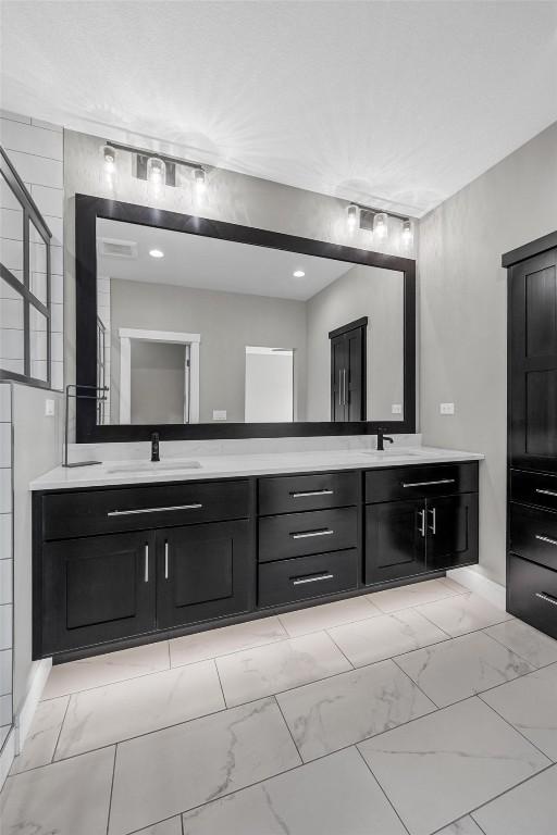 bathroom with marble finish floor, a sink, and double vanity