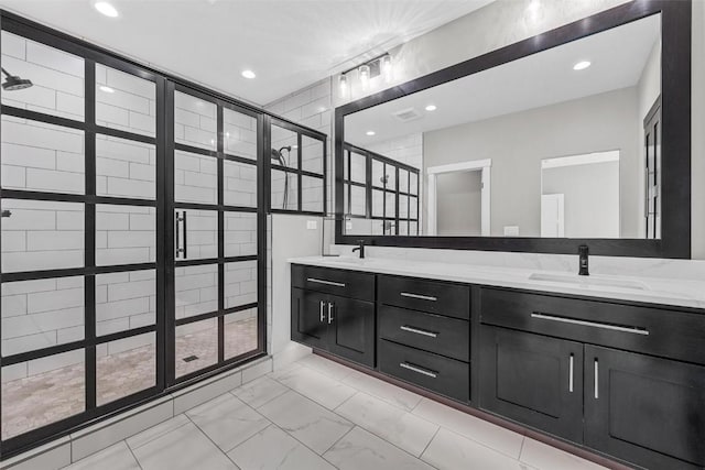 bathroom with double vanity, marble finish floor, a sink, and recessed lighting