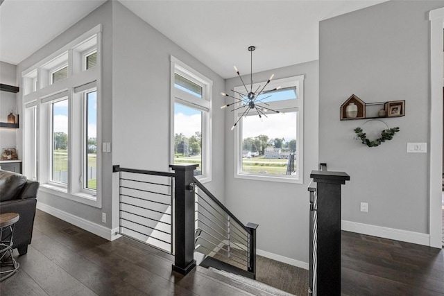 stairs featuring a chandelier, baseboards, and wood finished floors