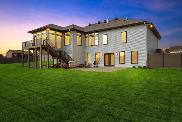 rear view of house with a yard, fence, stairway, and a patio