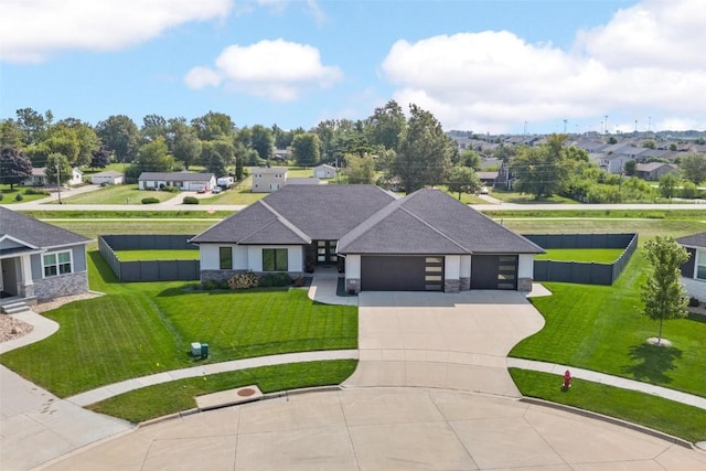 view of front of home featuring driveway, stone siding, a residential view, an attached garage, and a front lawn