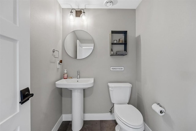 bathroom with toilet, visible vents, baseboards, and a sink