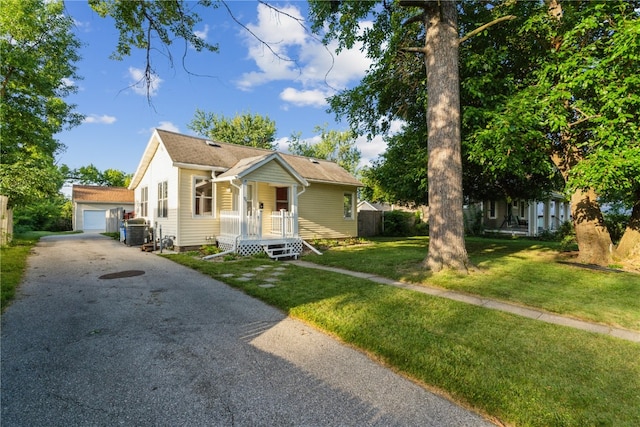 bungalow-style home with a front lawn, a garage, and central AC unit