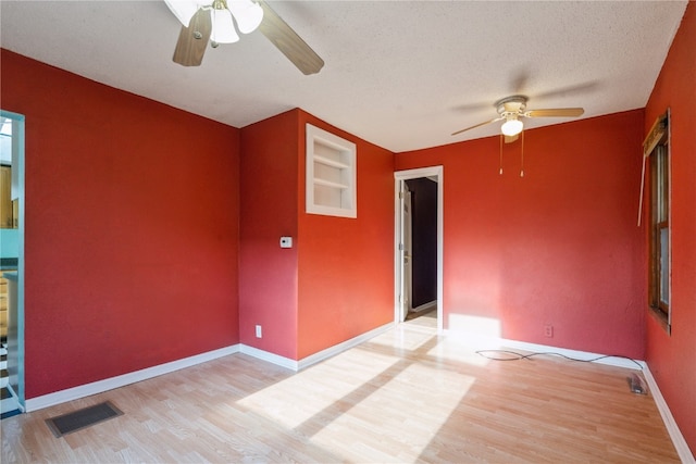 spare room with light wood-type flooring, a textured ceiling, and ceiling fan