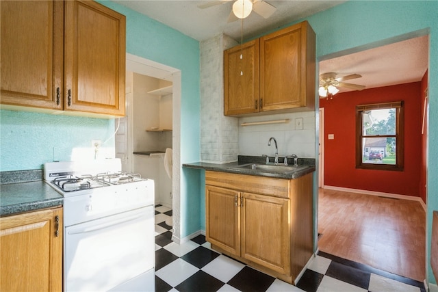 kitchen with light hardwood / wood-style floors, white range with gas stovetop, sink, and ceiling fan