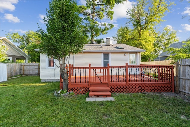 back of property featuring a deck and a lawn