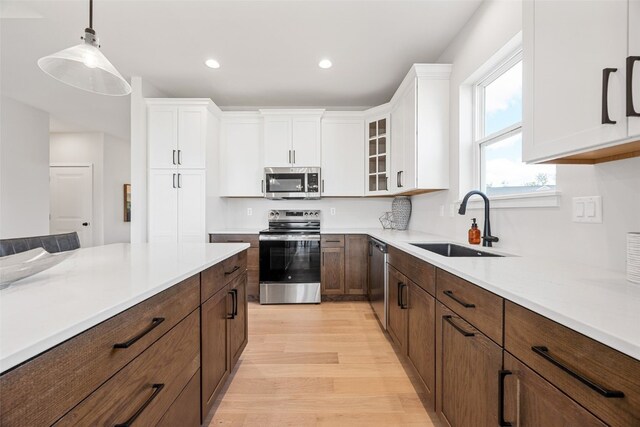 5638 Meadow Grass Cir SE, Cedar Rapids, IA 52403 - kitchen with appliances with stainless steel finishes, a sink, white cabinetry, light wood-type flooring, and recessed lighting