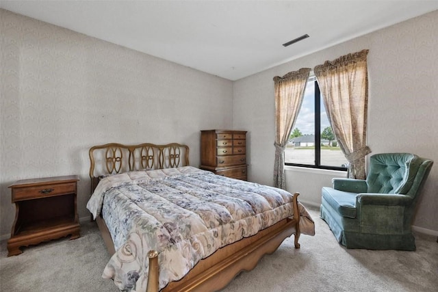 bedroom featuring light carpet, visible vents, and wallpapered walls