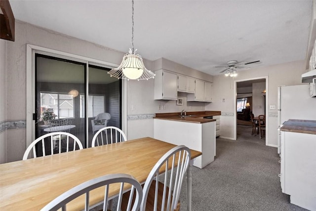 dining space with dark carpet and a ceiling fan